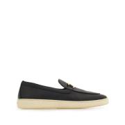 Sorte flate slip-on sko med gull-tone logo